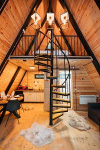 - un escalier en colimaçon dans une chambre située dans un bâtiment en bois dans l'établissement Campulung Chalets, à Bughea de Sus