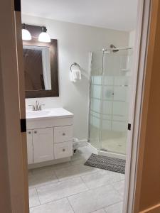 a bathroom with a shower and a sink and a mirror at Entire Guest suite & Vacation home in Whitehorse in Whitehorse