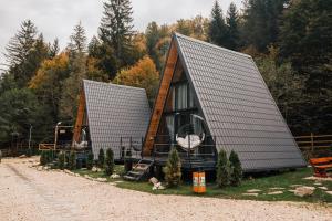 a tiny house with a pitched roof on a yard at Campulung Chalets in Bughea de Sus