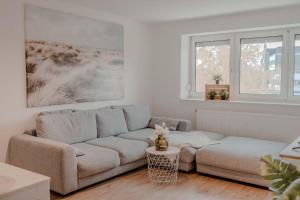 a living room with a couch and a table at Apartment mit Küche, Arbeitsplatz und XXL Sofa in Neuss