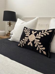 a black and white pillow on top of a bed at Avalon Beach Cottage- The Islander in Avalon