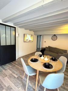a living room with a table and a couch at Maison Cosy , parking gratuit , 5 min aux Auxerre in Auxerre