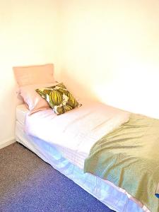 een klein bed in een hoek van een kamer bij Las Olas ~ Entire home with hot tub in Tythegston
