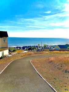 een lege weg naast de oceaan met een huis bij Las Olas ~ Entire home with hot tub in Tythegston