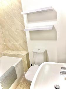 een badkamer met een wit toilet en een wastafel bij Las Olas ~ Entire home with hot tub in Tythegston