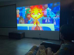 a person sitting in front of a video game screen at Family home, close to beach and town in Moruya Heads