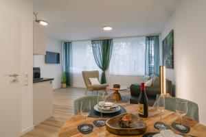 a living room with a table with a bottle of wine at Modernes 2-Zimmer Themen-Apartment "Frankenwald" im Zentrum in Bayreuth