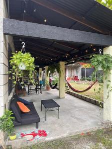 a patio with a couch and tables and plants at Pipa House Samara in Sámara