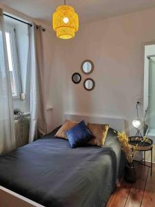 a bedroom with a bed with blue sheets and a window at L’Elégant in Douai