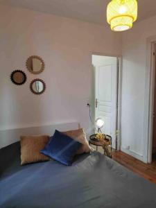 1 dormitorio con cama con almohadas azules y espejo en L’Elégant, en Douai