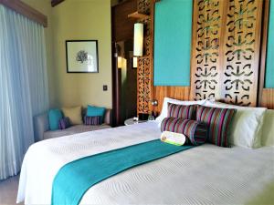 a bedroom with a large white bed in a room at Palafitos Overwater Bungalows El Dorado Maroma - Adults Only in Playa del Carmen