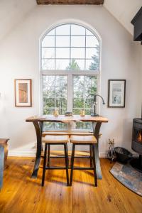a dining room with a table and chairs and a window at Quiet Riverside Retreat with 2 Fireplaces in Petite Rivière Bridge
