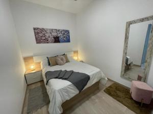 a bedroom with a large bed and a mirror at Alma in Madrid