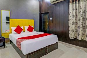 a bedroom with a large bed with red pillows at OYO Flagship Ideal Inn in Lucknow