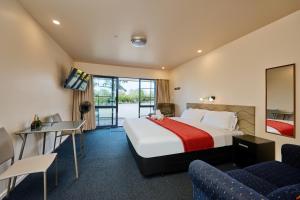 a hotel room with a bed and a table and chairs at Mediterranean Motel Kaikoura in Kaikoura