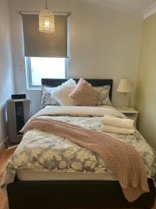 1 dormitorio con cama con almohadas y ventana en Whitfords Delight Homestay en Perth