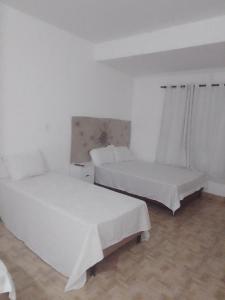 Una cama o camas en una habitación de EBORÀ Pousada Restaurante Petiscaria Disco Club