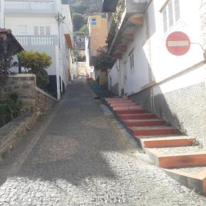 an alley in a village with red stairs at CasaMrichica in Ribeira Grande