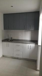 a kitchen with white cabinets and a counter top at CasaMrichica in Ribeira Grande