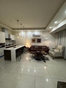 a kitchen and living room with a couch and a table at The Designer Den opposite to Centaurus mall in Islamabad