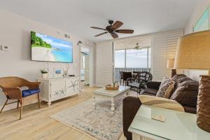 a living room with a couch and a flat screen tv at Fantastic Gulf Front Condo on the North end of the Island condo in Fort Myers Beach