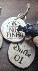 a wooden disc with a gun on a table at Pousada Nó de Pinho in Urubici