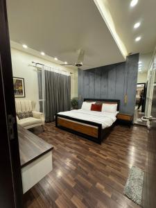 um quarto com uma cama e uma cadeira em The Designer Den opposite to Centaurus mall em Islamabad