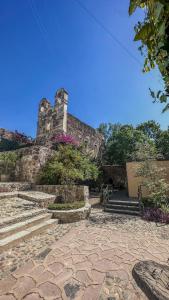 - un vieux bâtiment en pierre avec des escaliers et des fleurs dans l'établissement Antigua Guesthaus Suites, à Guanajuato