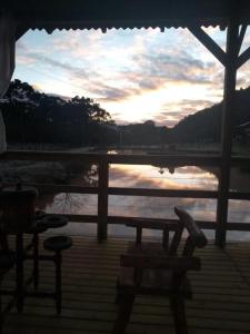 a porch with a table and chairs on the water at Pousada Nó de Pinho in Urubici +29 photos
