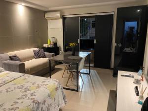 ein Wohnzimmer mit Sofa und Tisch in der Unterkunft Flat Aju - Um jeitinho especial de se hospedar em Aracaju. Uma verdadeira suíte master todo mobiliado no capricho só para você. in Aracaju