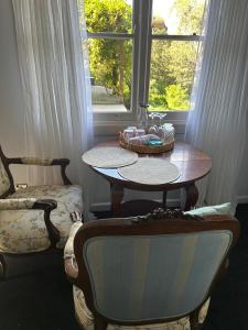 a table and a chair in a room with a window at Rainy Hill Retreat - The Cottage in Cockatoo