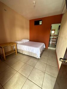 a small bedroom with a bed and a table at Hotel San Andres in Chiquimulilla
