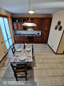 ein Esszimmer mit einem Tisch und Stühlen in einer Küche in der Unterkunft Villetta Camelia in Guamo