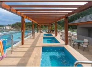 a swimming pool with a pergola and a swimming poolvisorvisorvisorvisor at Laghetto Resort Golden Gramado in Gramado
