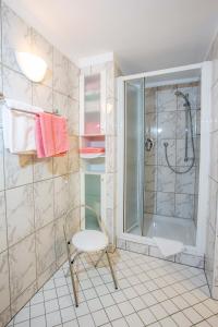 a bathroom with a chair and a shower at Ferienwohnungen Im Kelterhaus in Bad Herrenalb