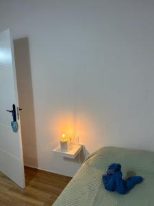 un animal de peluche azul acostado en una cama con una vela en Welcome to casa Coralia, 