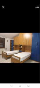 FaggianoにあるAppartamento L'Oleandro B&Bの青いキャビネット付きの部屋のベッド2台