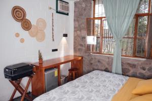 a bedroom with a bed and a desk and window at Hostal Pimampiro in Puerto Baquerizo Moreno