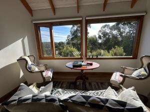 a room with a table and chairs and a window at Rainy Hill Retreat - The Loft in Cockatoo