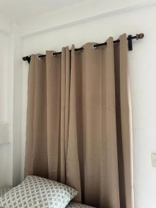 a curtain hanging on a wall next to a bed at Hotel San Andres in Chiquimulilla