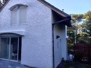 a white house with a window and a door at El lugar in Villa Gesell