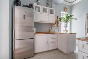 a kitchen with white cabinets and a stainless steel refrigerator at B&B Cumpari Turiddu in Syracuse