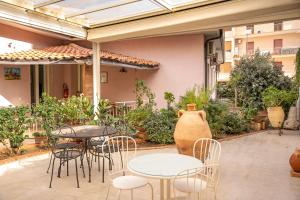an outdoor patio with tables and chairs and a vase at B&B Cumpari Turiddu in Siracusa