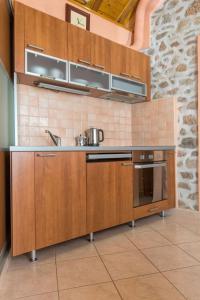 a kitchen with wooden cabinets and a sink at House Dinko in Bol +13 photos