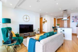 ein Wohnzimmer mit einem Sofa und einem TV in der Unterkunft Panoramic balcony luxury condo in London