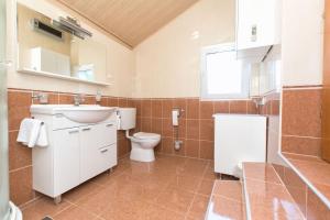 a bathroom with a sink toilet and a window at House Dinko in Bol