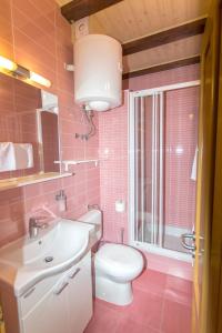 ボルにあるApartments La Perlaのピンクのバスルーム(トイレ、シンク付)