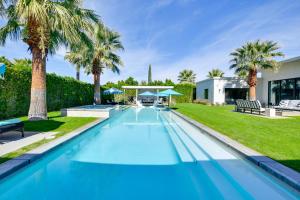 einen Pool mit Palmen und ein Haus in der Unterkunft Palm Springs Home Views and Luxe Outdoor Space! in Palm Springs