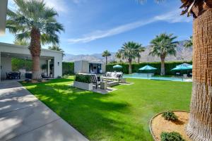 a backyard with palm trees and a lawn at Palm Springs Home Views and Luxe Outdoor Space! in Palm Springs