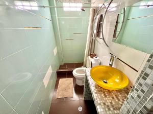 a bathroom with a yellow sink and a toilet at B&B - Trekking y Senderismo in Choachí